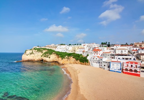 Die künsten der Algarve machen Portugal zu einem der beliebtesten Urlaubsziele für den Sommer - Strand und Häuser an der Küste der Algarve